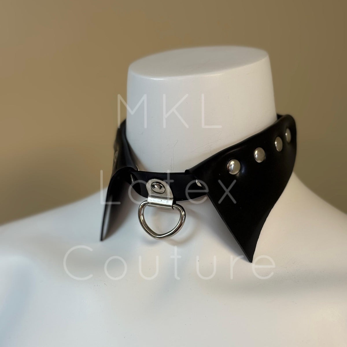 Latex choker collar made with heavy rubber latex. Center D-Ring with metal studs and back buckle for adjustment.