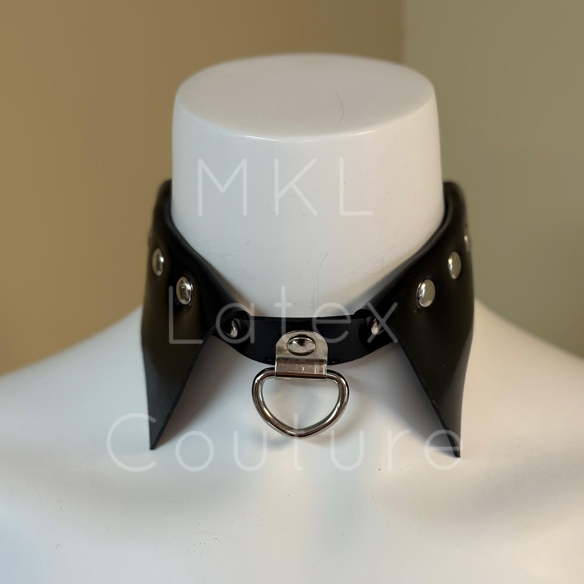 Latex choker collar made with heavy rubber latex. Center D-Ring with metal studs and back buckle for adjustment.