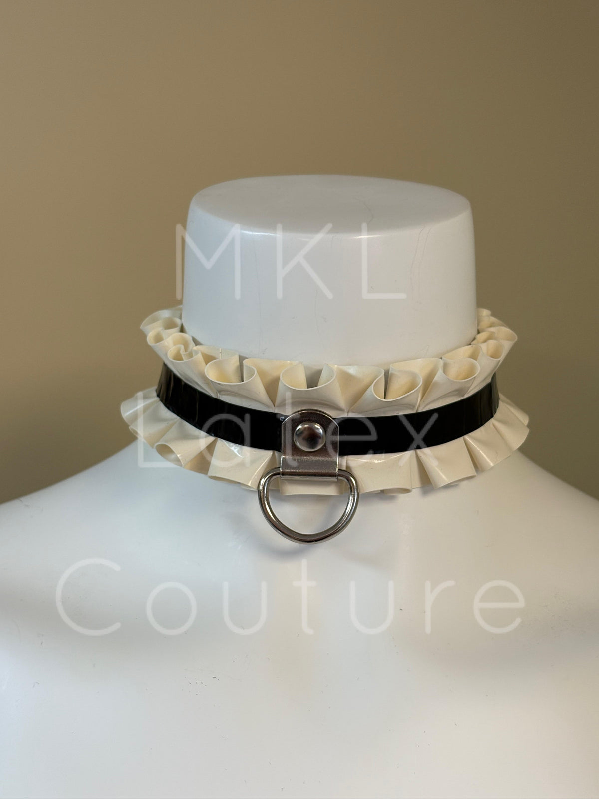 Latex ruffles choker made with heavy rubber latex and soft latex ruffles. Center D-Ring with metal stud and back buckle for adjustment.