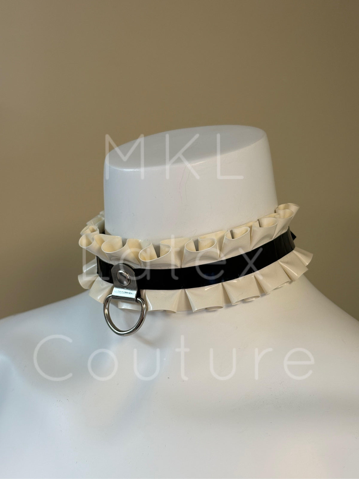 Latex ruffles choker made with heavy rubber latex and soft latex ruffles. Center D-Ring with metal stud and back buckle for adjustment.